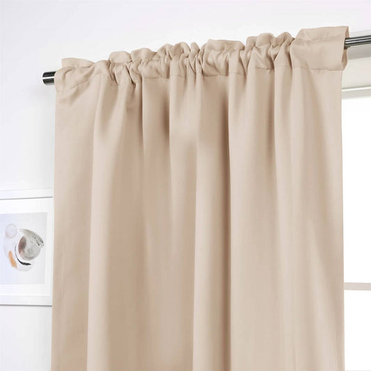 Beige curtain hanging on a rod against a white wall