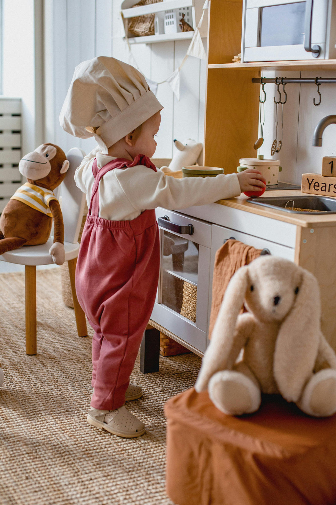 A small children’s playroom with natural lighting, wooden toys, and cozy textures designed to support quiet, imaginative play in a tiny space.