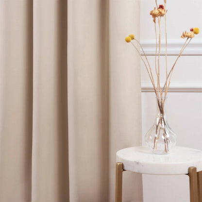 Beige curtain with a vase of dried flowers on a marble surface