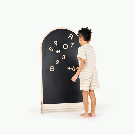 Child interacting with a blackboard with letters and numbers on a white background