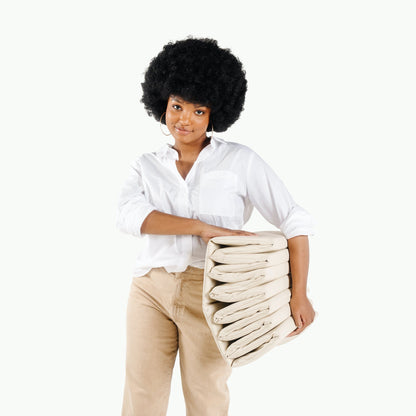 Woman holding a stack of folded blankets against a white background