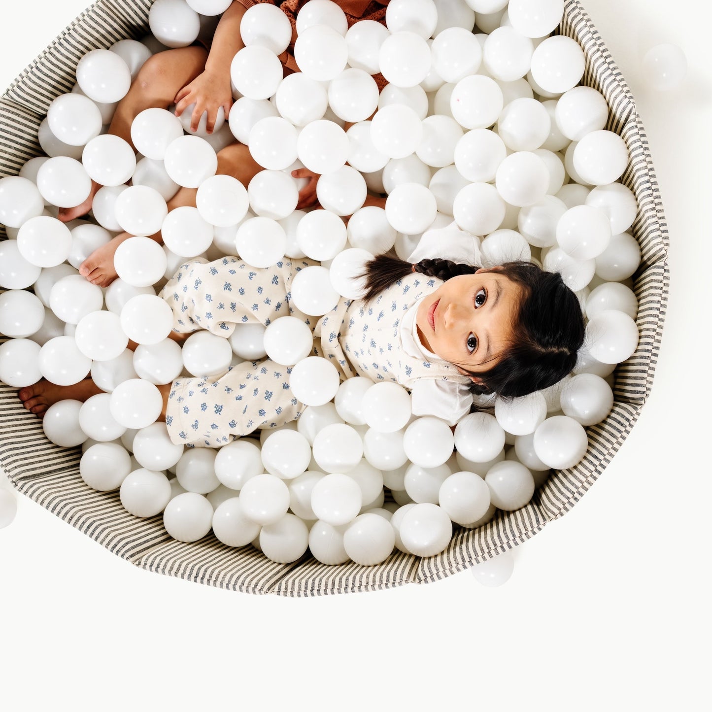 Children playing in a ball pit filled with white balls