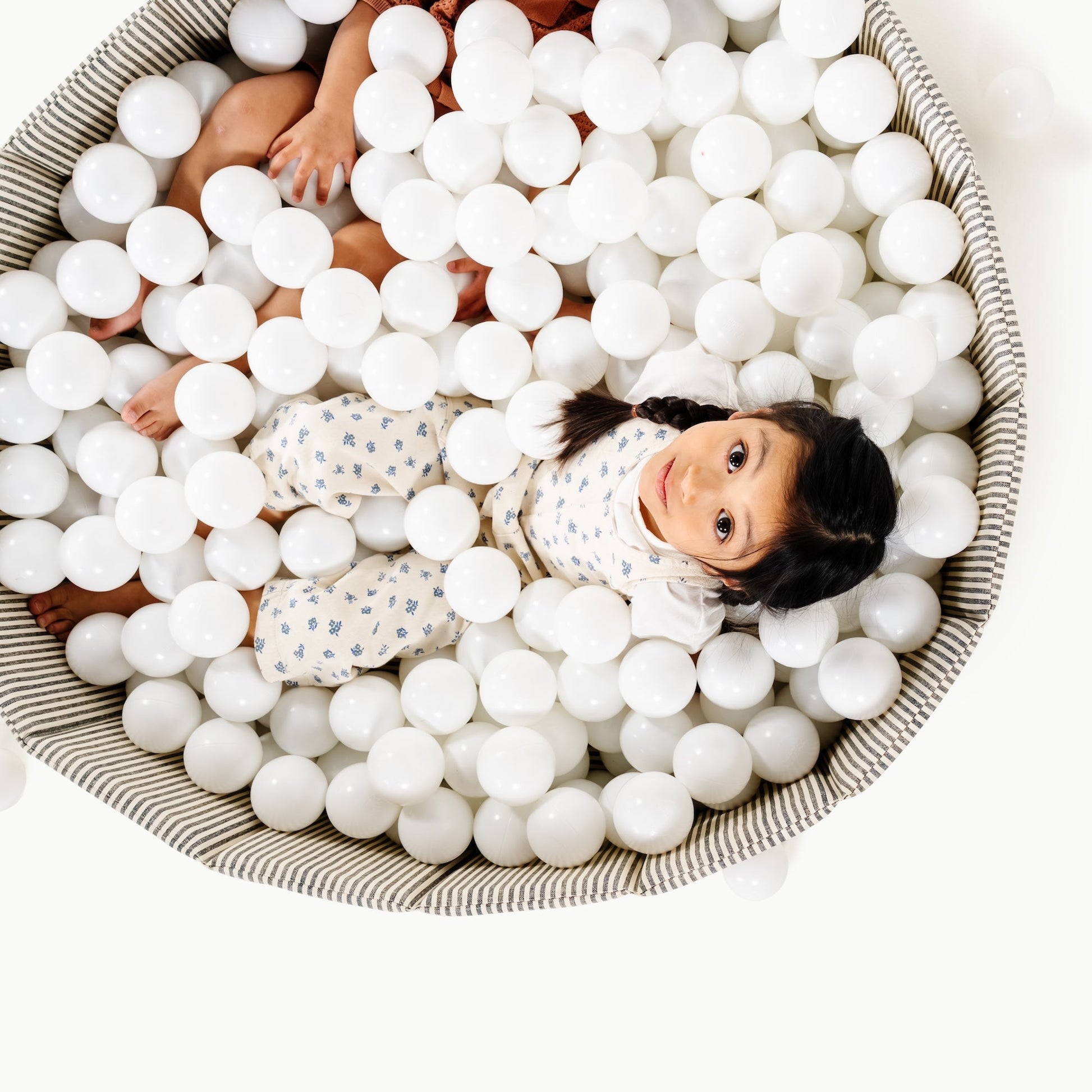 Children playing in a ball pit filled with white balls